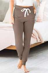 Dark brown jogging pants with pockets and tightening cord at the waist