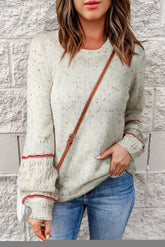 White sweater with patterned sleeves and pilled details