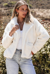 Beige jacket in faux fur with buttoned pockets and reverse neck