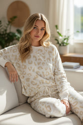 Sala de estar con suéter de leopardo blanco y pantalones de cordón en apriete