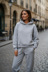 Set of plain gray sports clothing with hooded and jogging with exposed seams