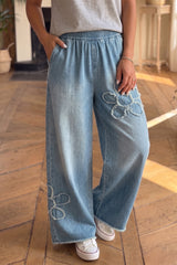 Jean large bleu à appliqués fleuris et bords bruts