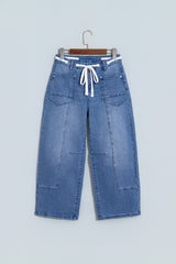 Jean ample bleu à taille haute, cordon et œillets, longueur cheville
