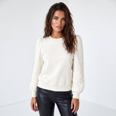 Sudadera blanca unida con mangas hinchadas y cuello redondo