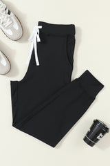Black jogging pants with pockets at the waist and tightening cord