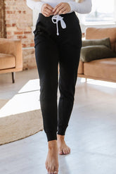 Black jogging pants with pockets at the waist and tightening cord