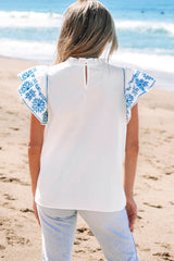 Blusa blanca bordada con mangas esponjosas y collar de volantes