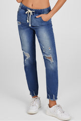 Jean bleu foncé à taille élastique, jambe droite, ourlet brut détruit
