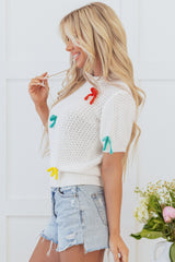 White sweater with short sleeves and knitted uphill collar with colorful knot
