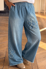 Jean large bleu à appliqués fleuris et bords bruts