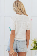 White sweater with short sleeves and knitted uphill collar with colorful knot